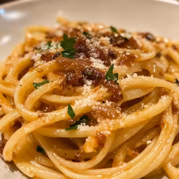 Caramelized Onion Pasta With Chilli Oil taken with iphone 15 pro max --iw 2 --ar 4:5 --v 6.1 --raw