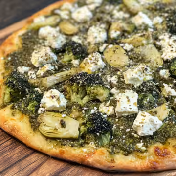 Green Pizza With Pesto Feta Artichokes Broccoli taken with iphone 15 pro max --iw 2 --ar 4:5 --v 6.1 --raw