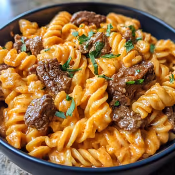 Spicy Garlic Butter Steak Cheddar Cream Rotini taken with iphone 15 pro max --iw 2 --ar 4:5 --v 6.1 --raw